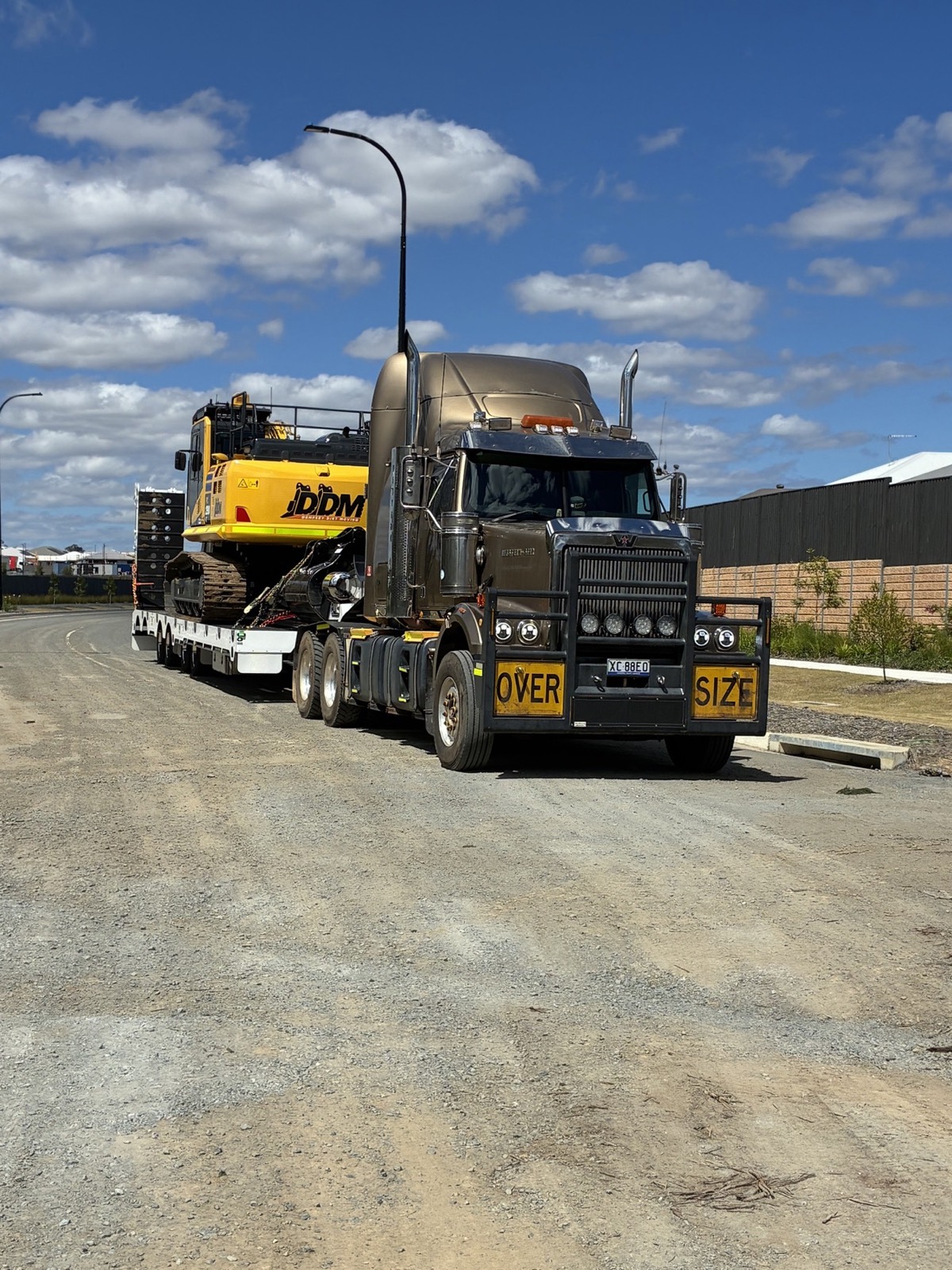 Western Star prime mover with an excavator on the float